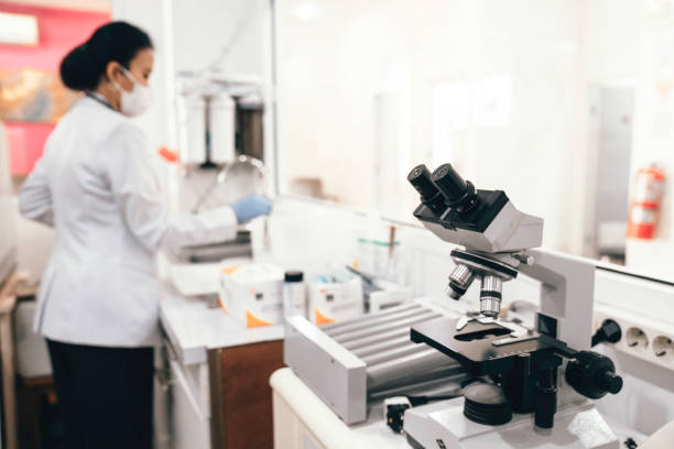 Water Apple microscope with asian female scientist working in the background